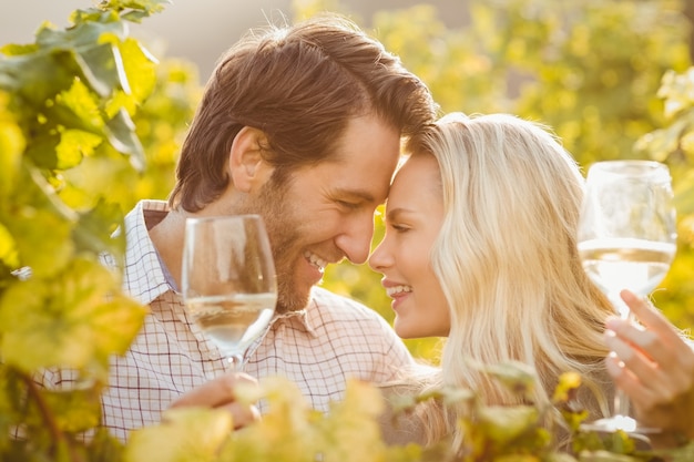 Joven pareja feliz sosteniendo copas de vino