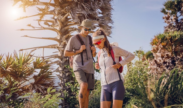 Una joven pareja feliz sube a la cima de las montañas cerca del océano.