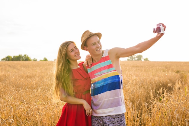 Joven pareja feliz tomando un selfie en el campo