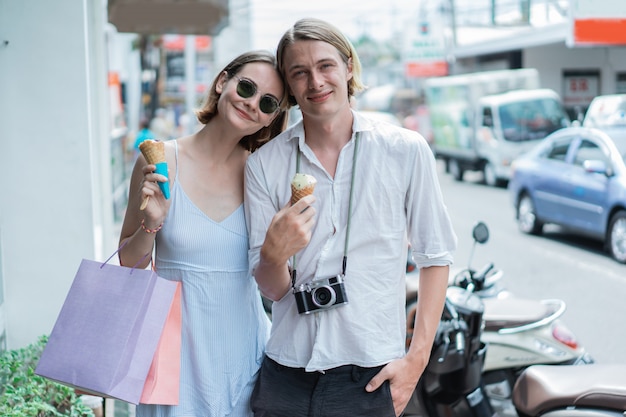 Joven pareja hermosa con bolsas de compras en la ciudad