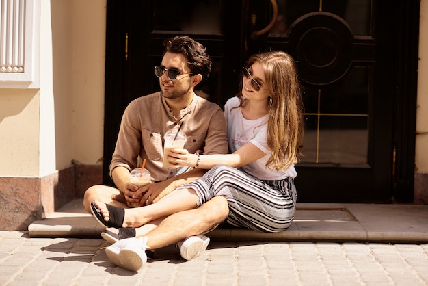 Joven pareja hermosa divertirse y caminar por las calles de la ciudad y tomar café