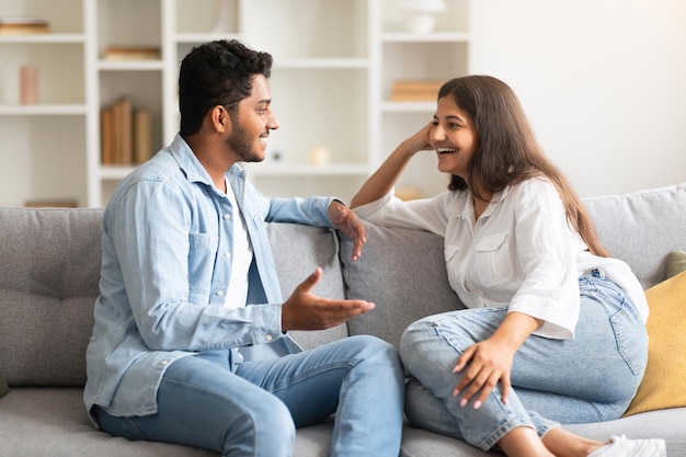 Joven pareja india amorosa hablando y coqueteando disfrutando de una conversación en casa pasando tiempo juntos