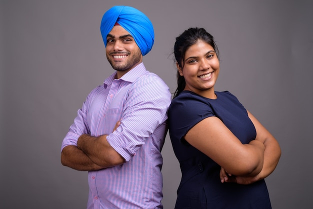 Joven pareja india juntos y enamorados contra la pared gris