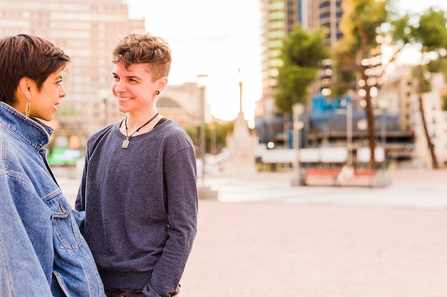 Joven pareja de lesbianas tomboy transexual andrógino no binario y una mujer hispana con pelo corto