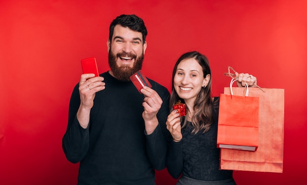 Joven pareja linda está entusiasmada con compras en línea con tarjeta de crédito.