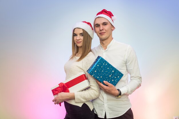 Joven pareja de moda celebrando el Día de San Valentín dándose regalos el uno al otro