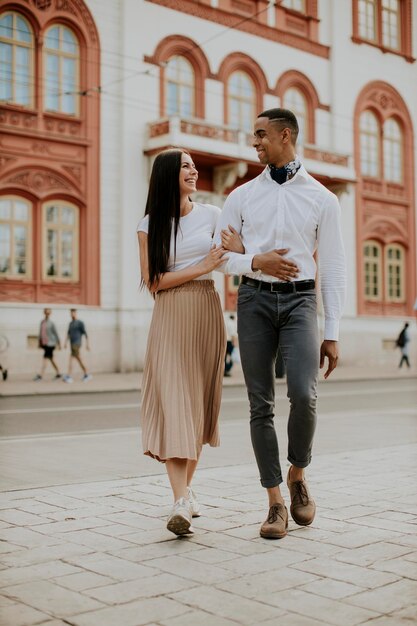 Joven pareja multiétnica caminando por la calle