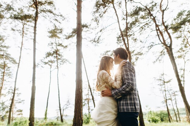 Una joven pareja de novias caminando en el bosque de pinos