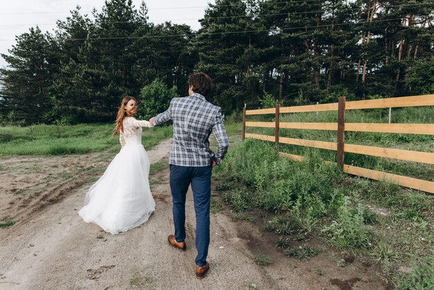 Una joven pareja de novias se divierte y camina en el campo al aire libre