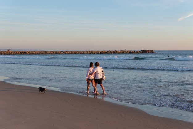 Una joven pareja paseando por la orilla del mar