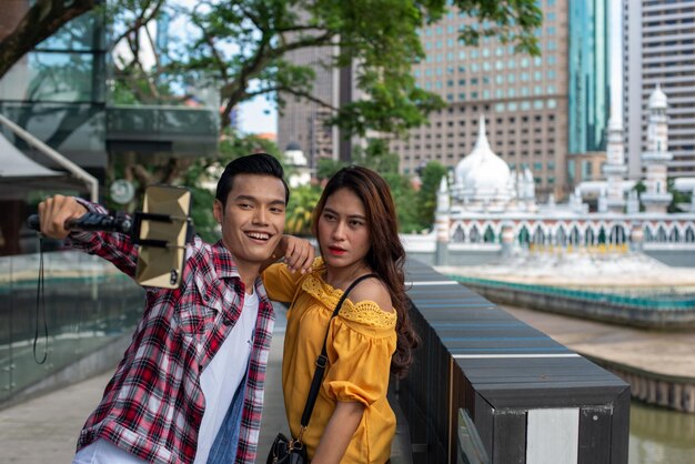 Foto una joven pareja de pie frente a un canal en una ciudad