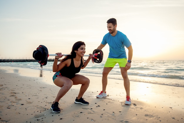 Joven pareja en la playa, hacer ejercicio.