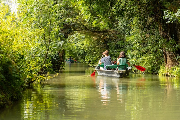 Una joven pareja remando el barco navegando entre La Garette y Coulon, Marais Poitevin la Venecia Verde, cerca de la ciudad de Niort, Francia