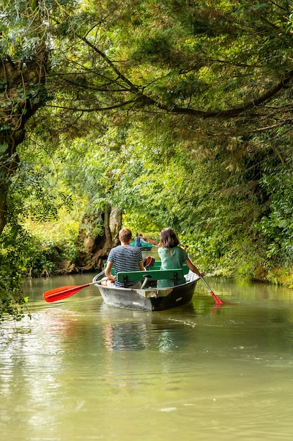 Una joven pareja remando el barco navegando entre La Garette y Coulon, Marais Poitevin la Venecia Verde, cerca de la ciudad de Niort, Francia