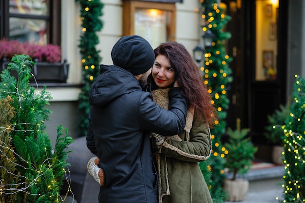 Joven pareja romántica se divierte al aire libre en invierno antes de Navidad.