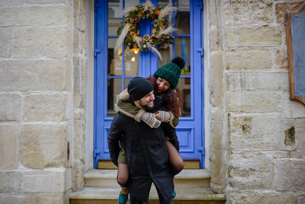 Joven pareja romántica se divierte al aire libre en invierno antes de Navidad.