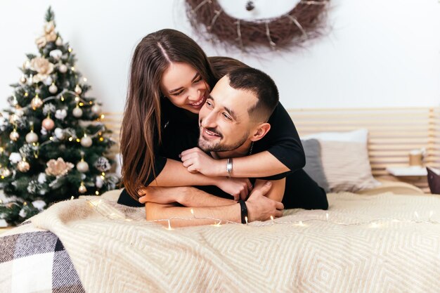 Joven, pareja romántica, mentira en cama, y, abrazar