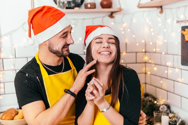 Joven pareja romántica de pie en la cocina y divertirse