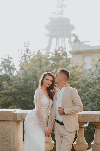 Joven pareja romántica de pie frente a la Torre Eiffel