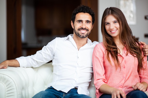 Joven pareja en el sofá en el amor