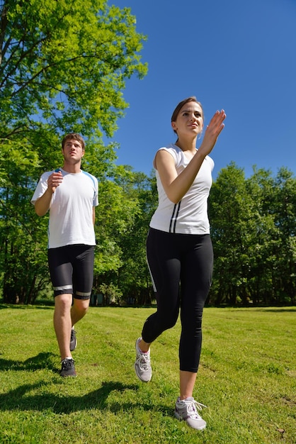 Joven pareja trotando en el parque por la mañana. Concepto de salud y fitness