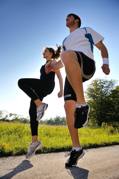 Joven pareja trotando en el parque por la mañana. Salud y Belleza.