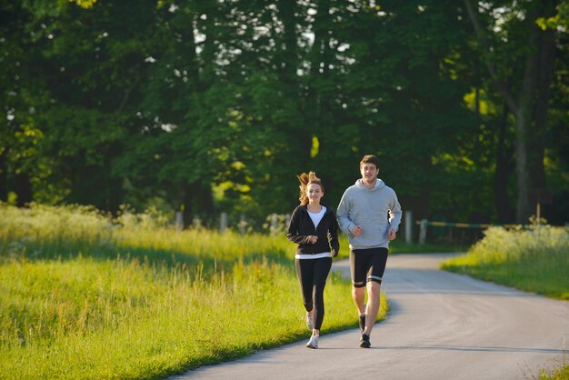 Joven pareja trotando en el parque por la mañana. Salud y Belleza.