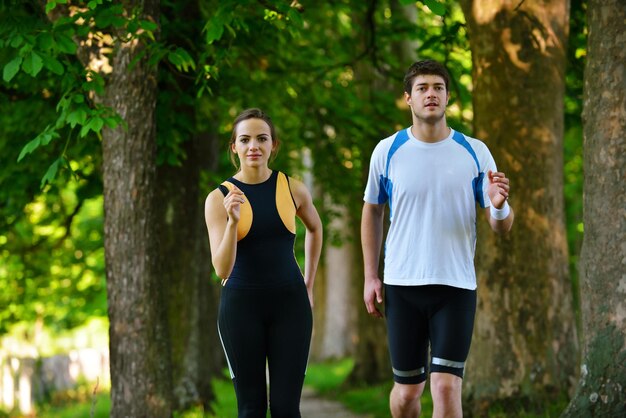 Joven pareja trotando en el parque por la mañana. Salud y Belleza.