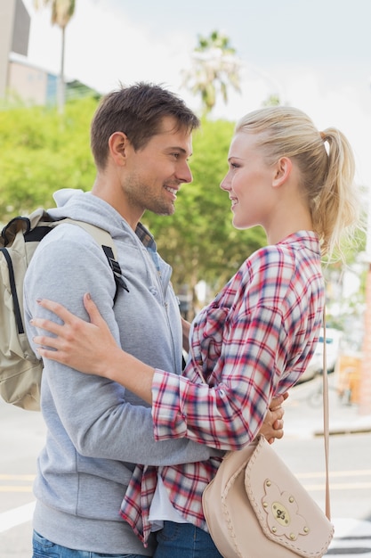 Joven pareja de turistas abrazándose unos a otros