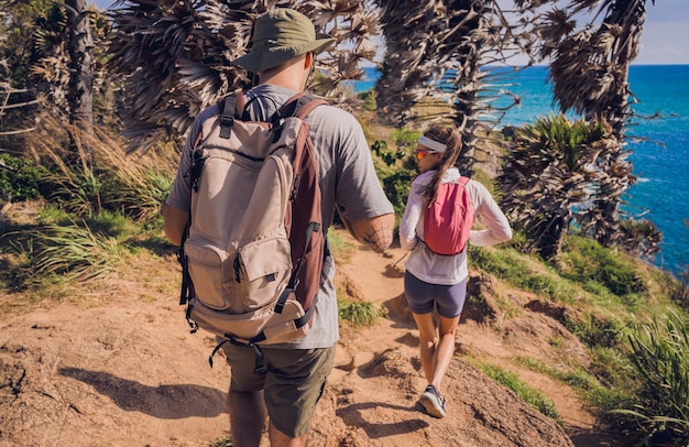 Foto una joven pareja viajando en el bosque de la selva cerca del océano