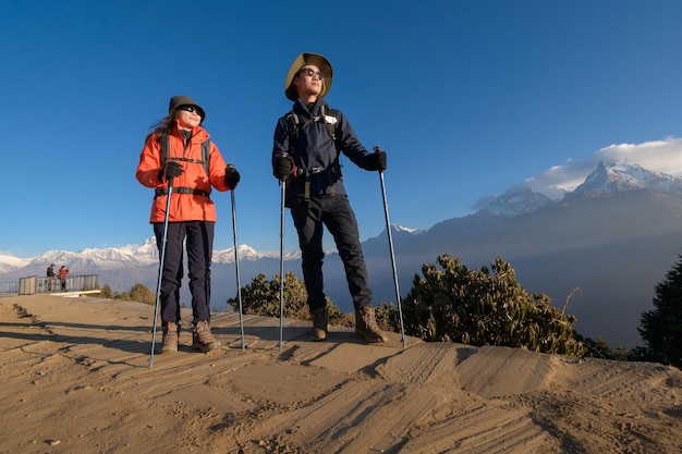 Una joven pareja de viajeros haciendo senderismo en el punto de vista de Poon Hill en Ghorepani Nepal