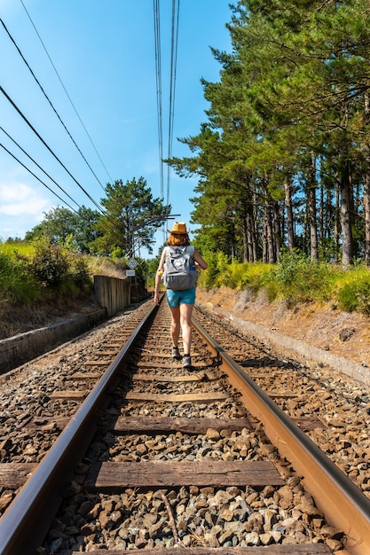 Una joven paseando por las vías del tren de Urdaibai, reserva de la biosfera de Bizkaia junto a Mundaka. país Vasco