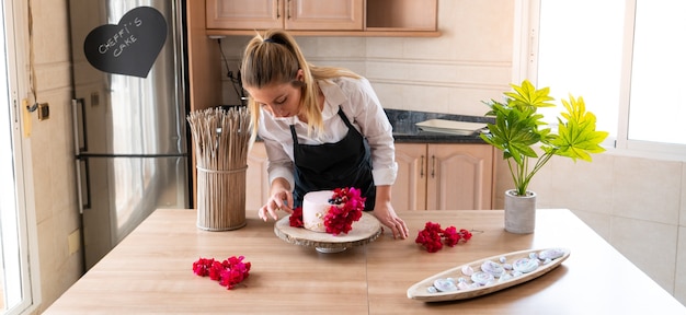 Joven pastelero cocinando un pastel de terciopelo rojo tradicional en la cocina