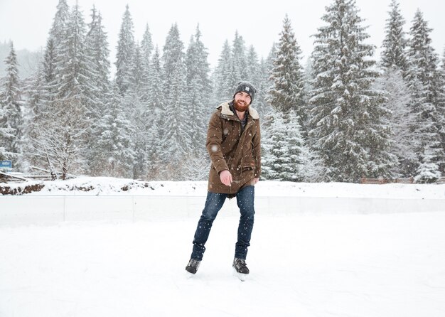 Joven patinaje sobre hielo al aire libre con nieve