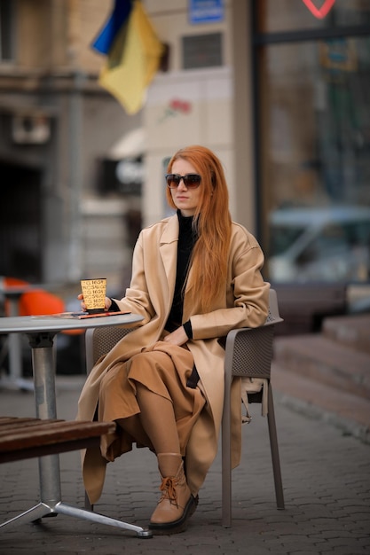 joven pelirroja bebiendo café en un café