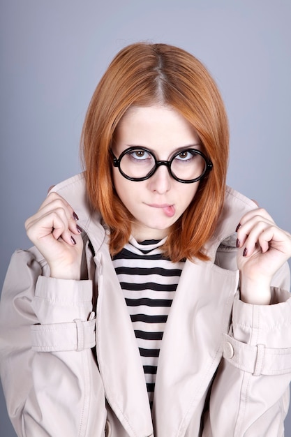 Joven pelirroja con gafas y manto.