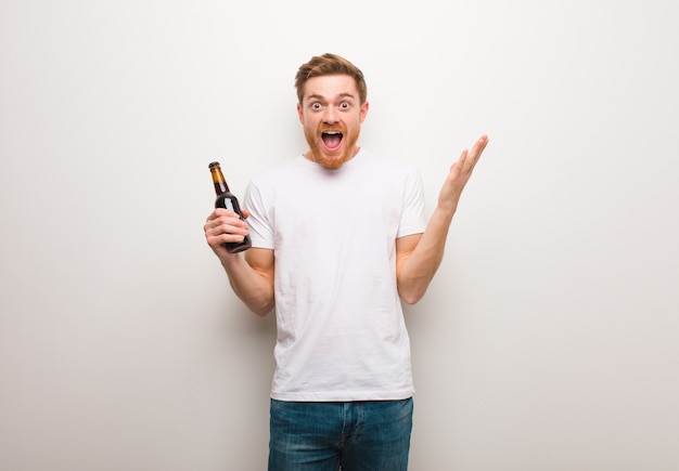 Joven pelirroja. Sosteniendo una cerveza.