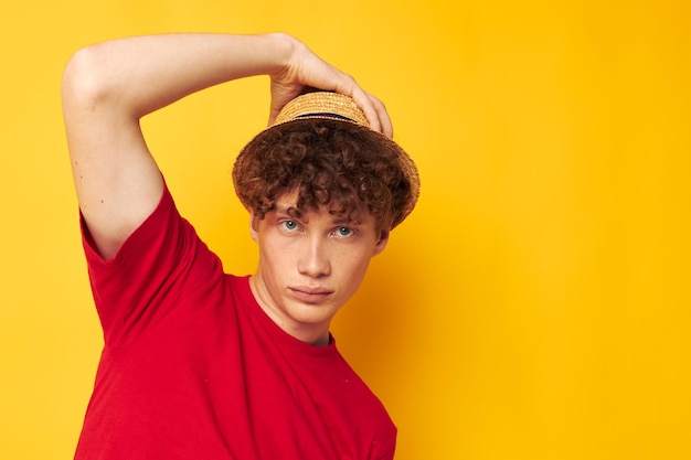 Joven de pelo rizado con una camiseta roja y un sombrero de moda Estilo de vida inalterado