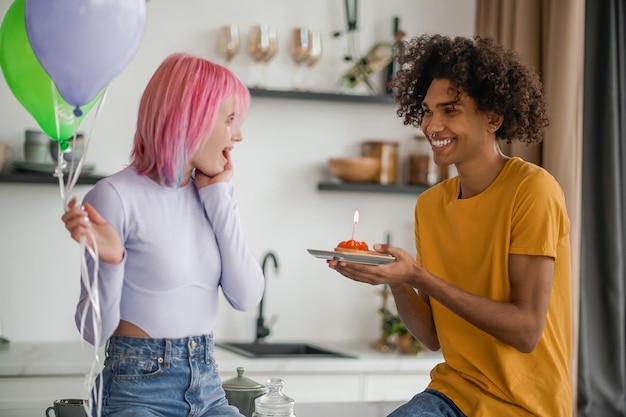 Joven de pelo rizado felicitando a su novia con el día de san valentín