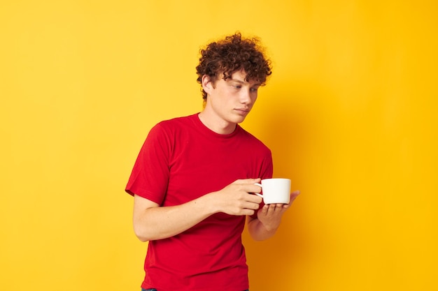 Joven de pelo rizado posando con una taza blanca y en manos de una bebida Estilo de vida inalterado