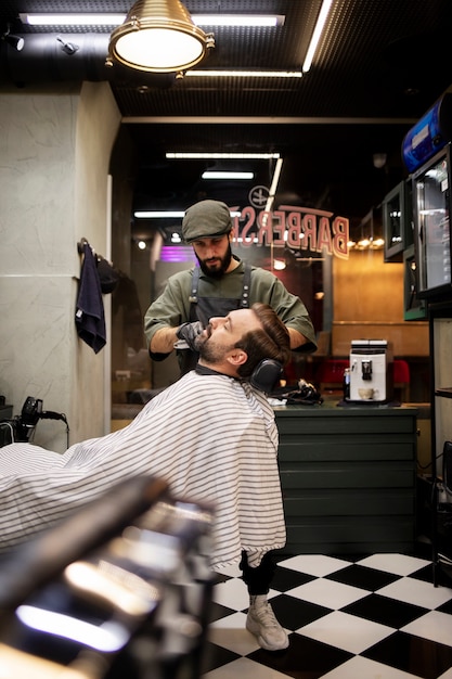 Foto joven en la peluquería recortándose la barba