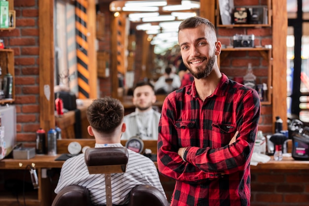 Joven peluquero con camisa sonriendo satisfecho