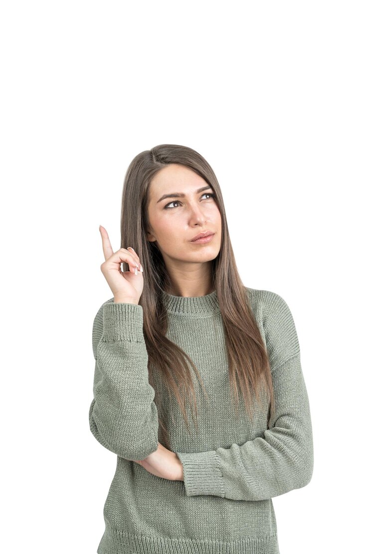 Foto una joven pensativa con el cabello largo y oscuro lleva una sudadera verde y apunta hacia arriba con el dedo.