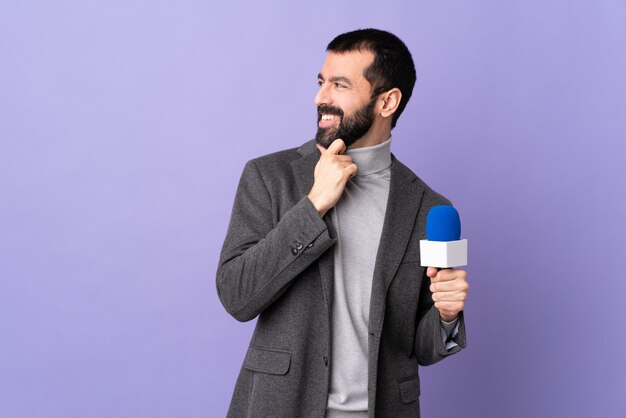 Joven periodista hombre sobre pared aislada