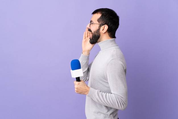 Joven periodista hombre sobre pared aislada