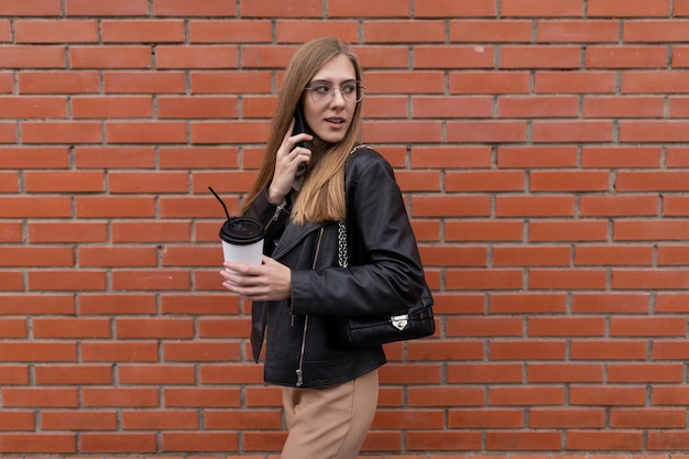 Joven periodista paseando por la ciudad con café