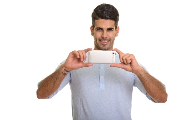 Joven persa feliz sonriendo y tomando fotografías con teléfono móvil