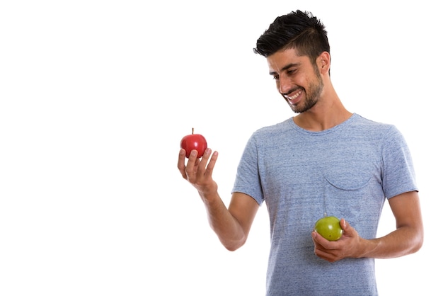 Joven persa sosteniendo manzana roja y manzana verde