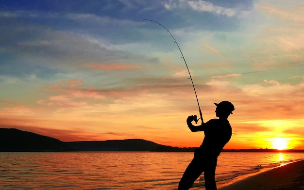 Joven pescando en un lago al atardecer