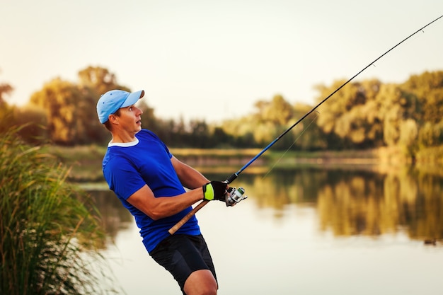 Joven pescando en el río al atardecer